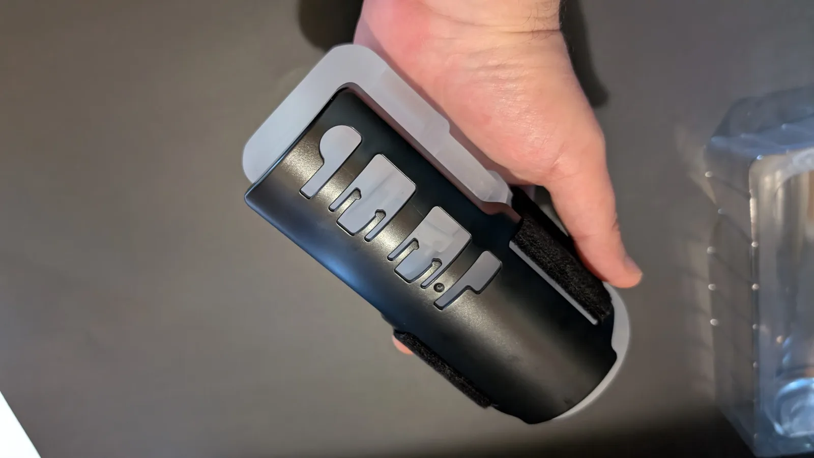 Black hard-plastic Solace Pro Grip Kit holder with cutouts along its length, wrapped around the clear sleeve