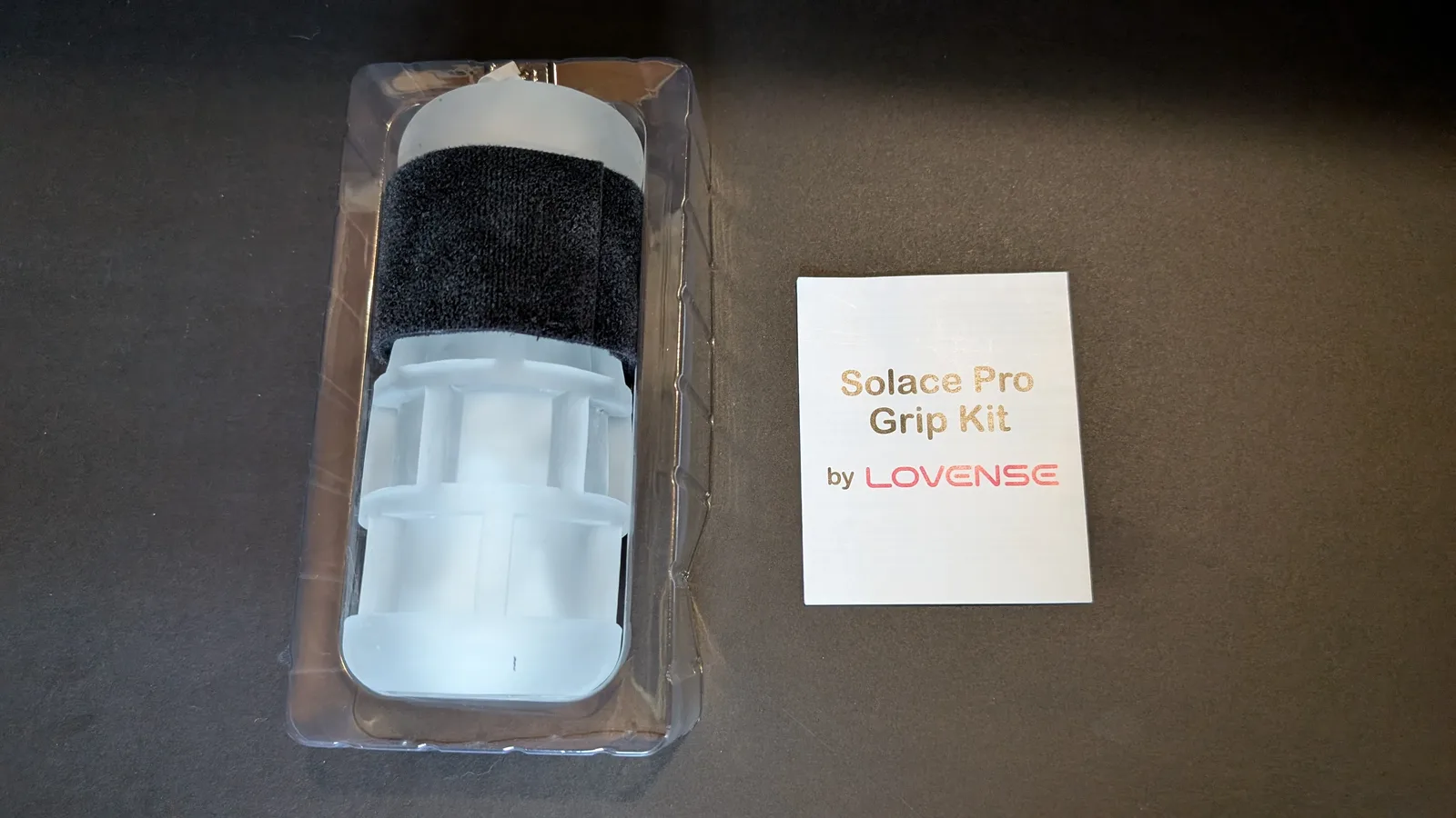 Solace Pro Grip Kit in its clear plastic tray beside the Lovense instruction card